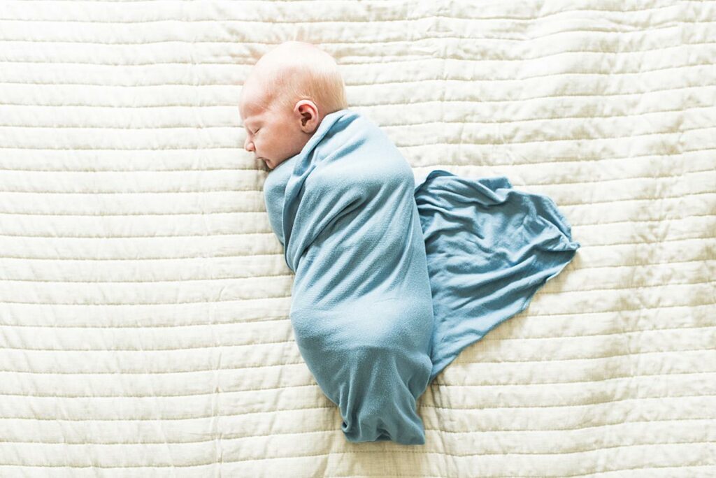 baby boy, swaddled, blue, on bed