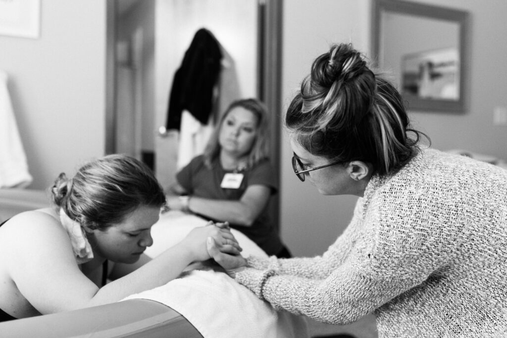 doula helping laboring mom in tub, birth center, fears about birth photography