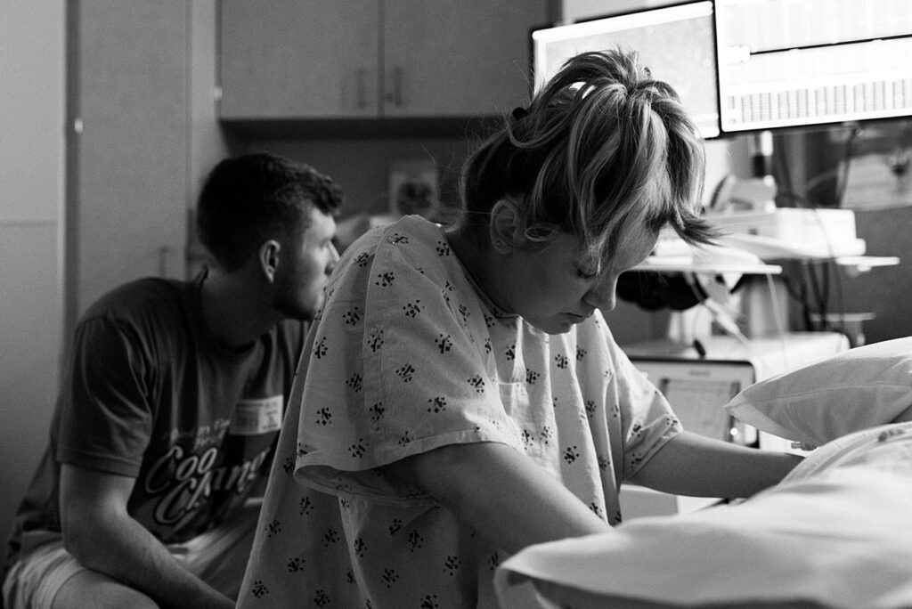 mom leaning over hospital bed during labor