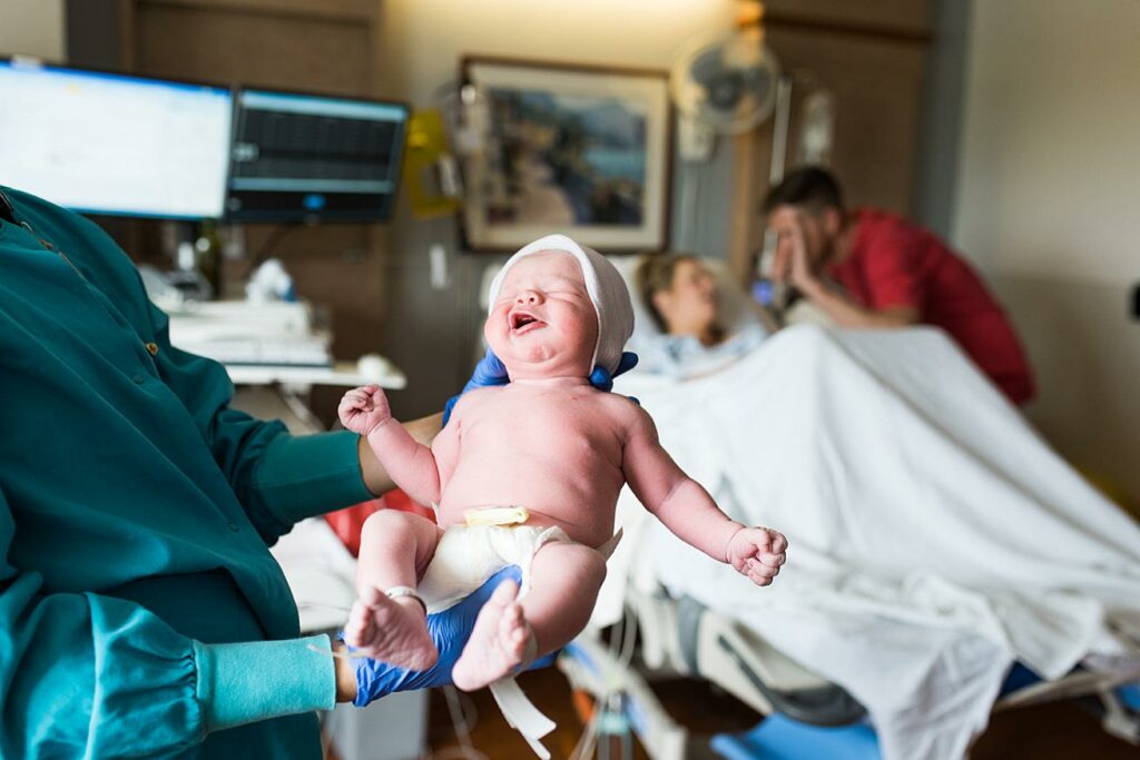 nurse holding baby boy in hospital