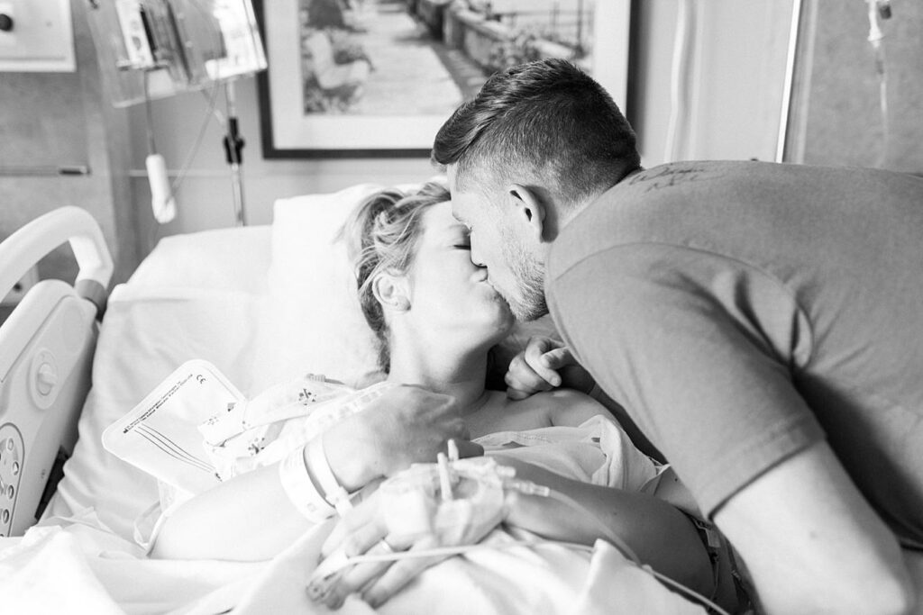 mom and dad kissing after birth of baby boy