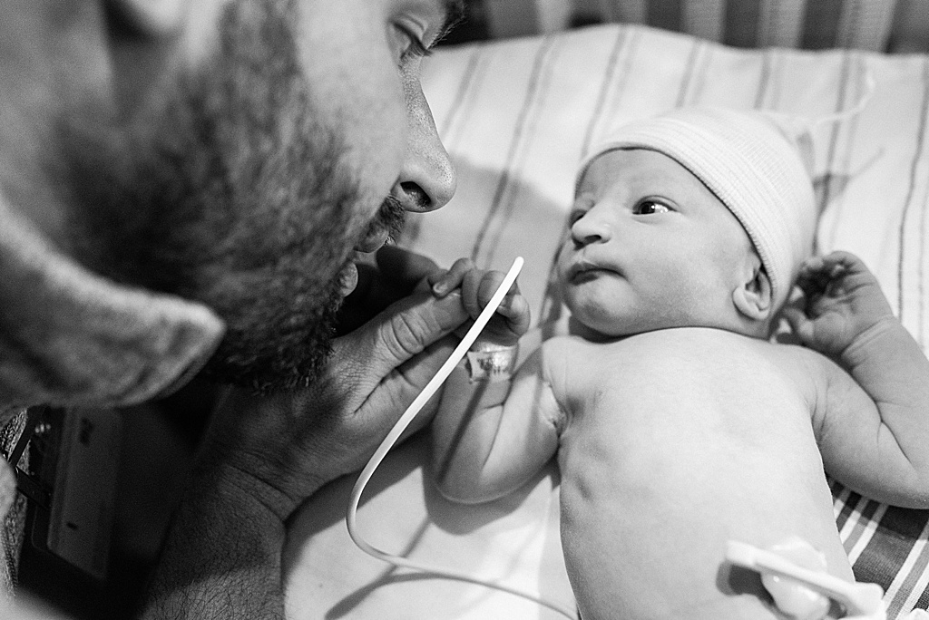 newborn baby boy looking at dad