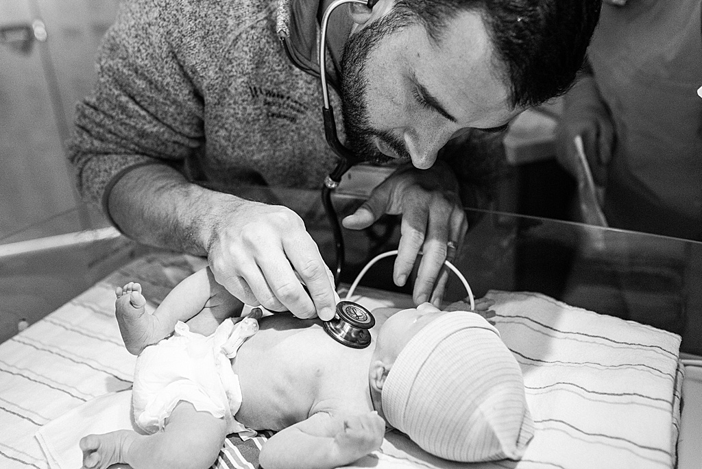 cardiologist dad checking newborn's heart rate
