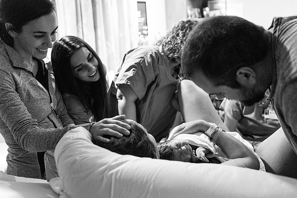 family surrounding mom after baby is born